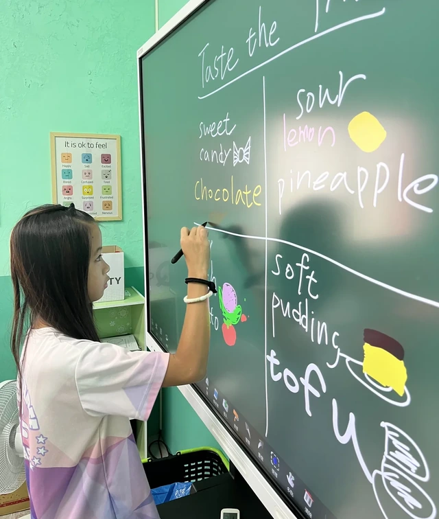 孩子在全美語課堂上用智慧黑板練習英文